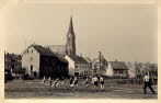 Im Vordergrund der Sportplatz an der Ill mit der Rckseite der Huser in der unteren Kirchenstrae und dem Turm der Kirche.